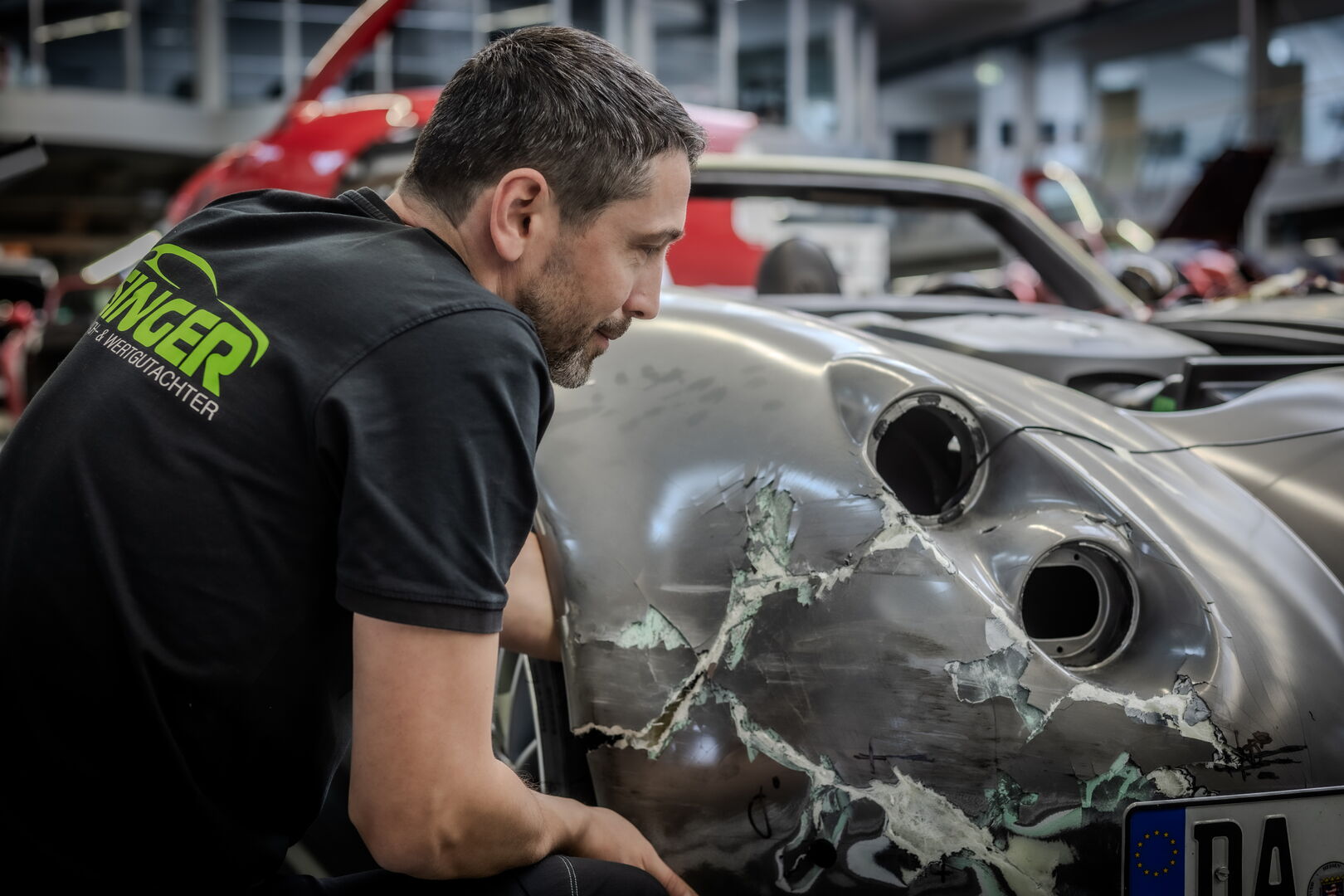 Viktor Isinger untersucht einen Karosserieschaden an einem Wiesmann